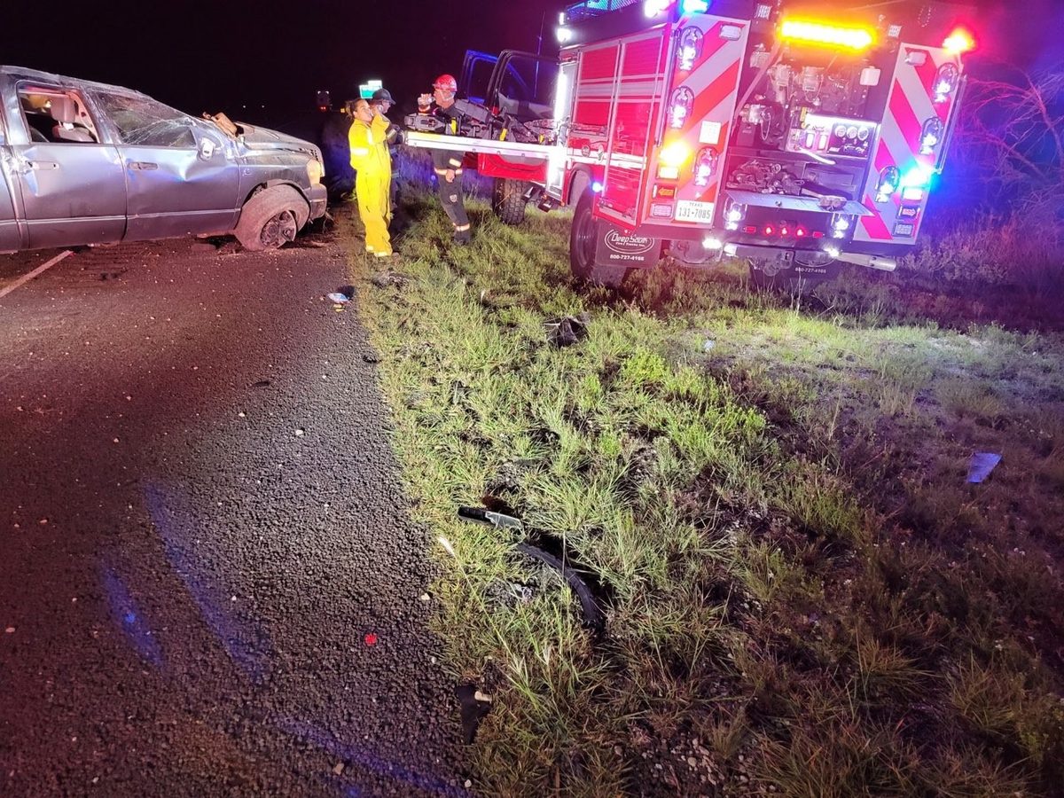 Firefighters and EMS crews working a nighttime vehicle crash on a rural highway in Crockett County