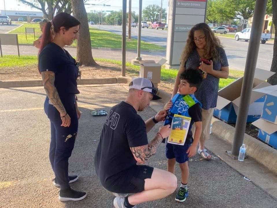 CVRAC volunteers fitting a child with a life jacket at a community safety event